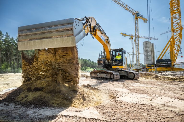 Bagger beim Verladen von Sand auf einer Baustelle, Bauarbeiten im Gange.