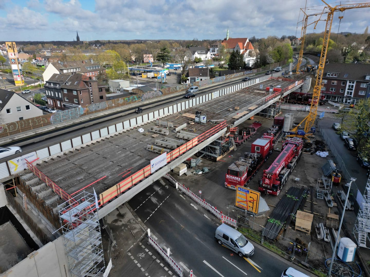 Hochbauarbeiten an einer Brücke mit Baugeräten und Fahrzeugen.