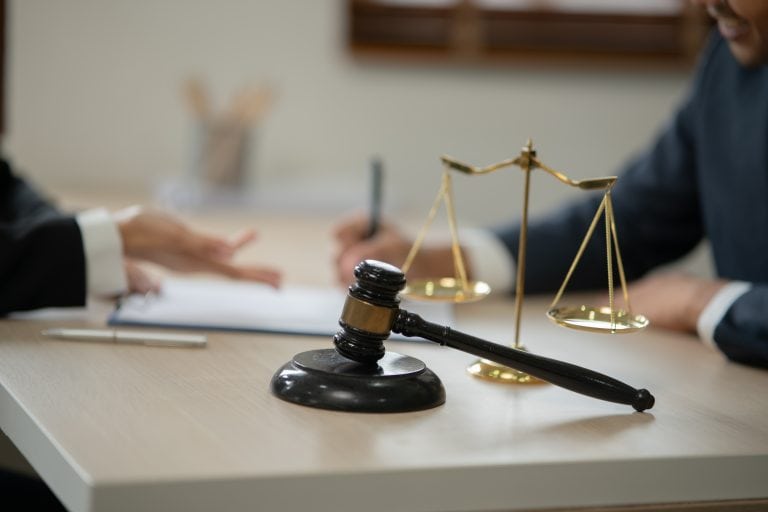 Ein Gerichtssaal mit Gavel, Waage und Notizen, symbolisiert Recht und Bauwi.