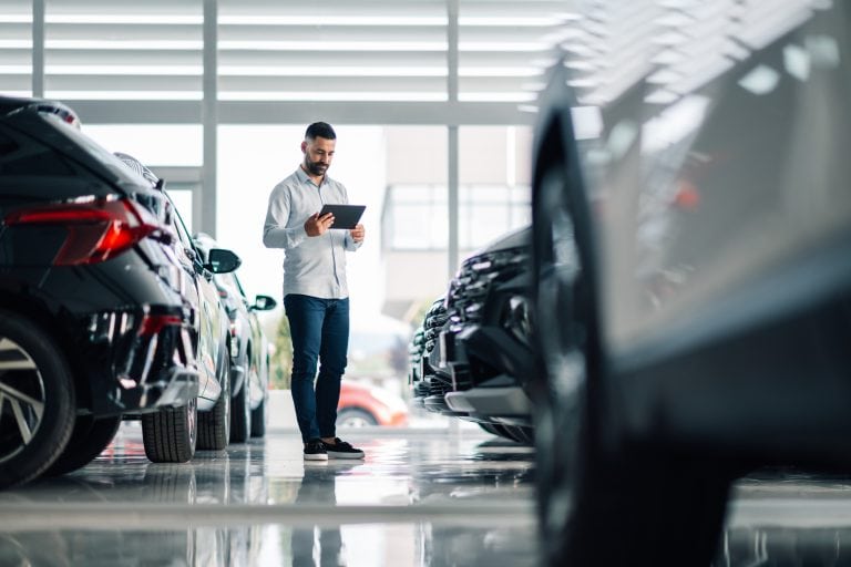 Mann prüft Autos im Autohaus.