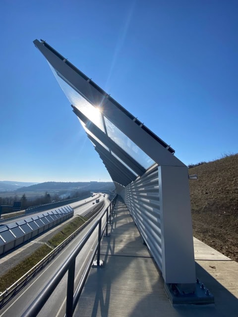 Solarkollektoren auf Autobahnbrücke bei Sonnenschein.
