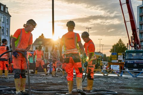 Arbeiter auf einer Baustelle bei Sonnenuntergang, im Einsatz.