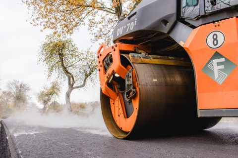 Asphaltwalze bei Straßenbauarbeiten auf neuem Asphalt.