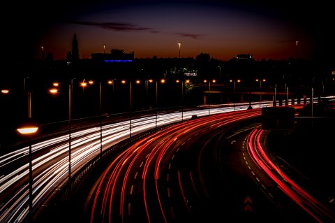 Straßenverkehr mit Lichtspuren bei Nacht.