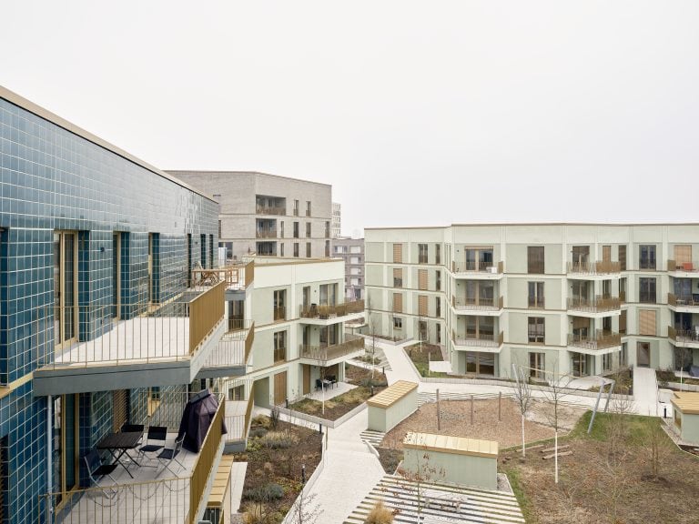Blick auf eine moderne Wohnanlage mit Balkonen und Gartenflächen.