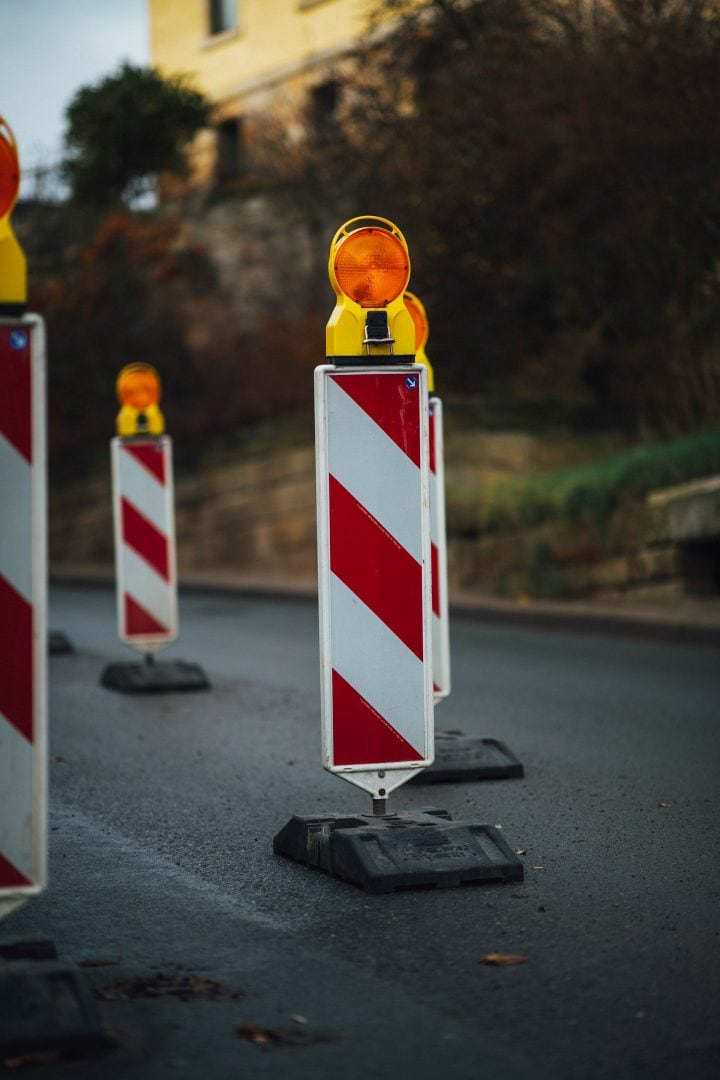 Baustellenabsperrungen mit Warnleuchten auf der Straße.